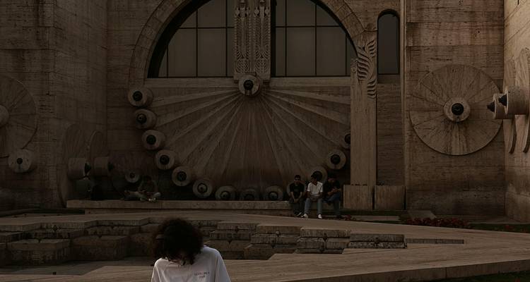 Détails architecturaux abstraits avec des personnes assises sur des marches.