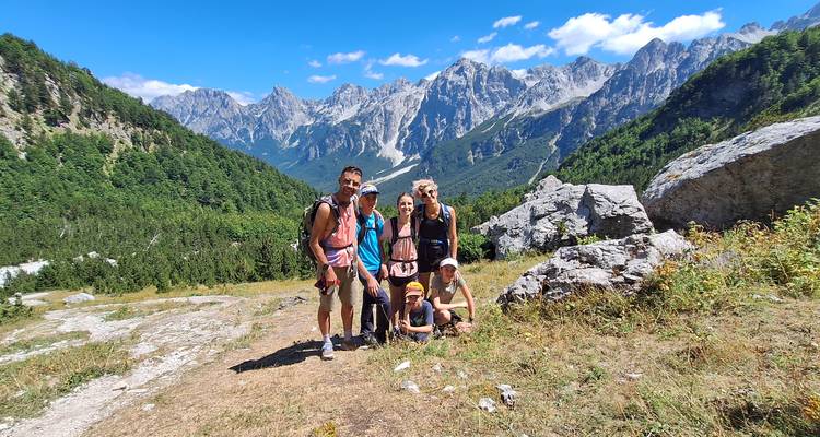 Group of hikers posing in front of a mountain range.