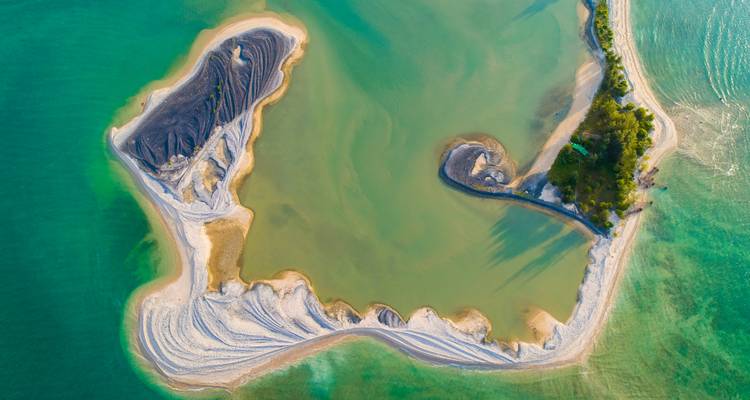 Luchtfoto van een unieke landformatie omgeven door water.