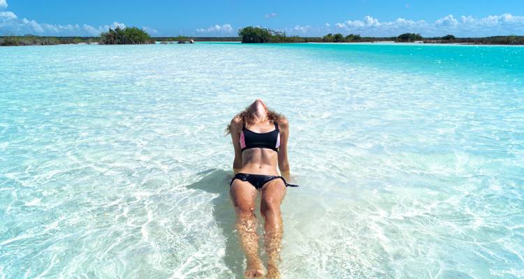 Een vrouw die luiert in kristalhelder water.