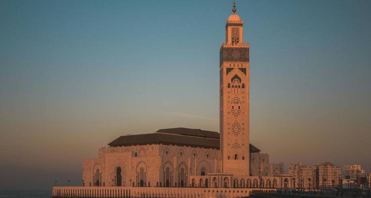 Grande mosquée au bord de la mer au coucher du soleil.