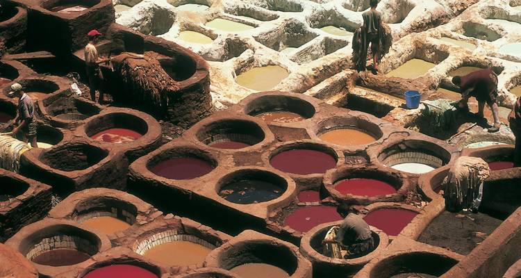 Travailleurs dans des tanneries traditionnelles avec des cuves colorées.