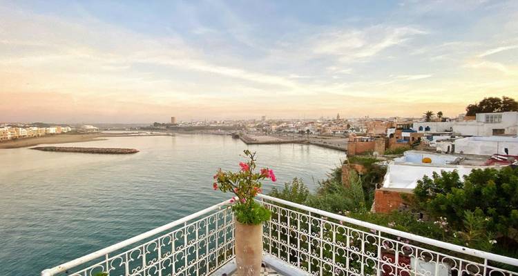 Vue côtière depuis le balcon donnant sur une ville et la mer.