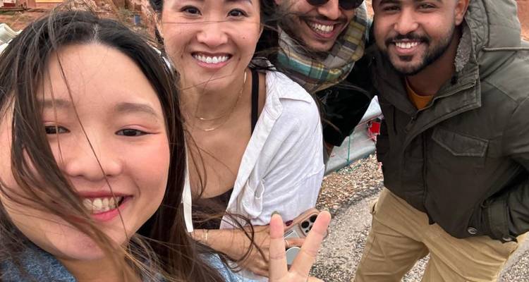 Gruppenselfie mit lächelnden Menschen im Freien.