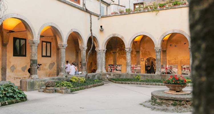 An inner courtyard with people and arches.