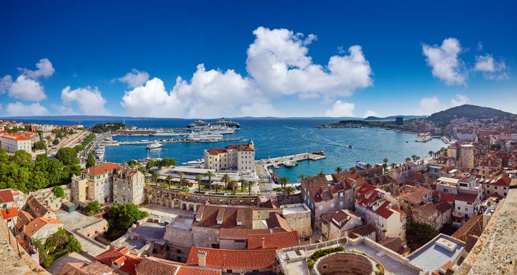 Vue aérienne d'une ville côtière avec un port et des bateaux.