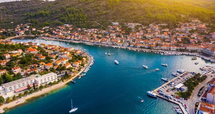 Vue aérienne d'un littoral avec des bateaux amarrés dans une baie.