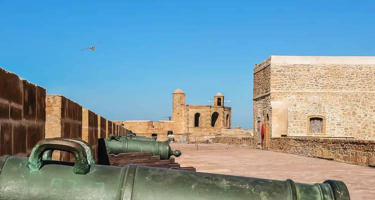 Cannons on a historical fort wall overlooking the sea.