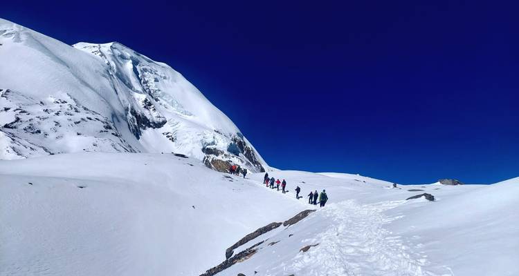 Wandelaars die trekken over een met sneeuw bedekte bergpas.