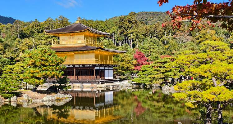 Golden pavilion surrounded by gardens and water.