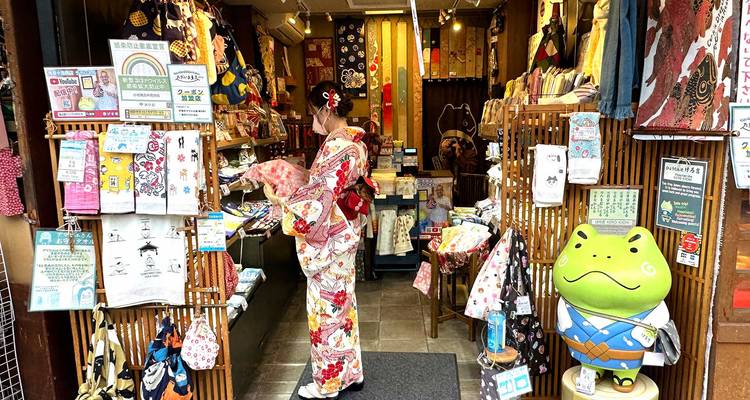 Person in traditional attire in a shop with colorful items.