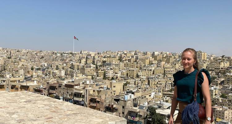 Personne avec une vue sur le paysage urbain d'Amman avec un drapeau.