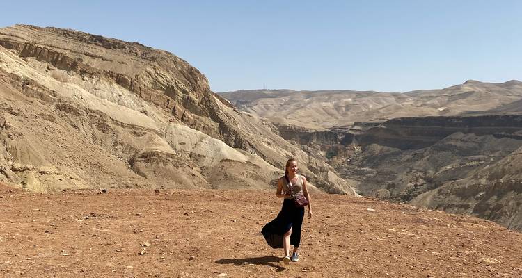 Personne debout dans un paysage vaste, rocheux et aride.