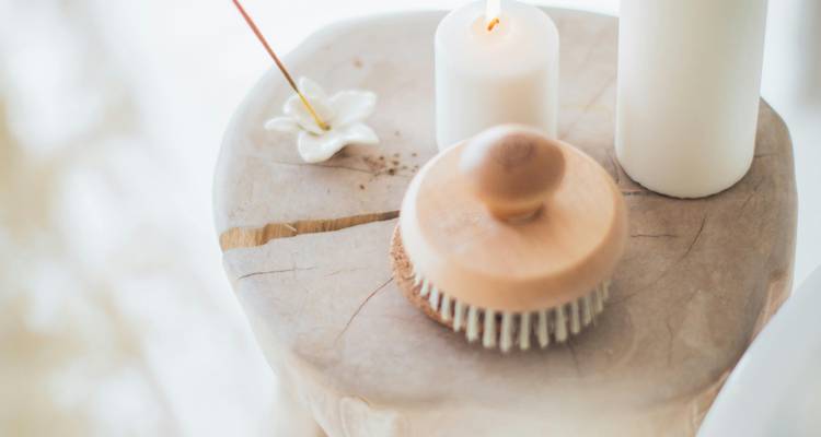 Décoration naturelle sur le thème du spa avec des bougies et une brosse pour le corps.