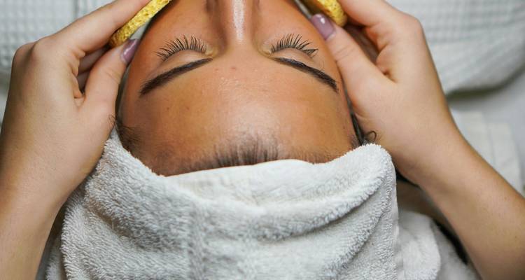 Gros plan d'une personne recevant un soin du visage dans un spa.