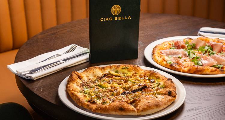 Gros plan de pizzas gastronomiques sur une table de restaurant.