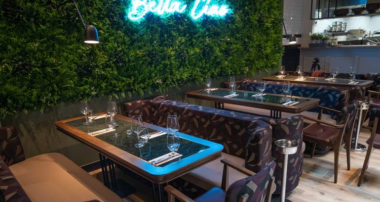 Intérieur d'un restaurant avec de la verdure et une décoration élégante.