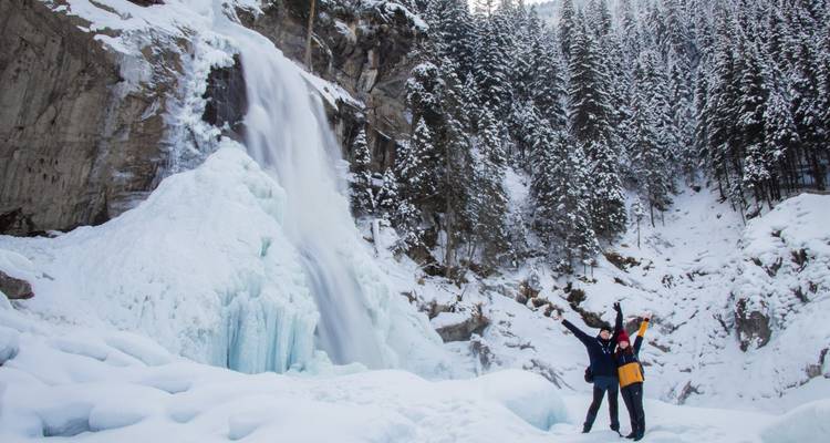 Deux personnes posant devant une cascade gelée.