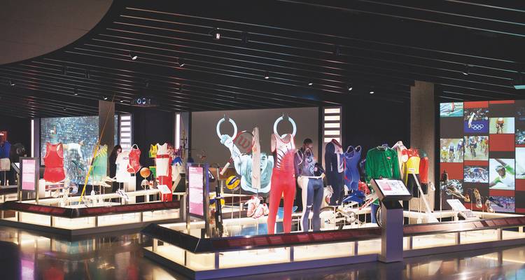 Exhibit displaying colorful sports equipment with several mannequins.