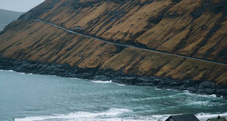 Vue côtière avec flanc de colline escarpé et route.