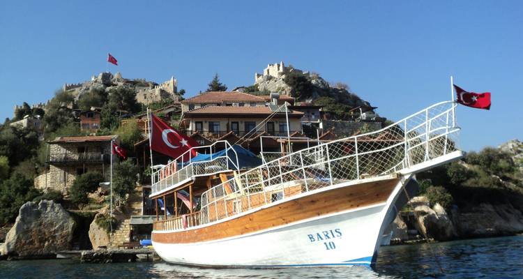 Holzboot auf einem klaren blauen Meer mit türkischen Flaggen.