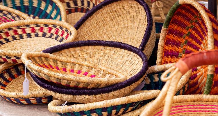 Paniers tissés colorés exposés dans un marché.
