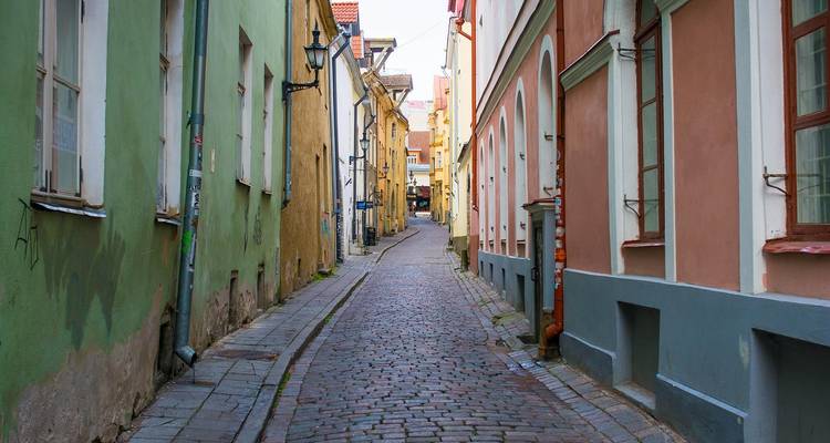 Rue pavée étroite bordée de bâtiments colorés.