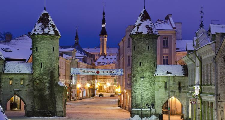 Entrée enneigée d'une ville fortifiée historique la nuit.