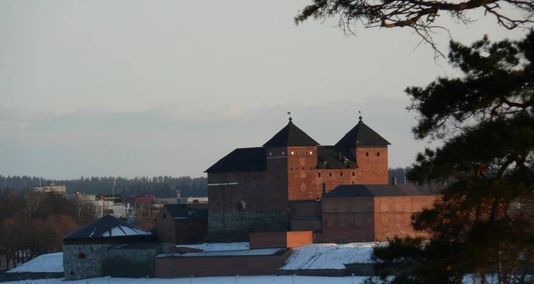 Vue éloignée d'un château historique avec de la neige environnante.