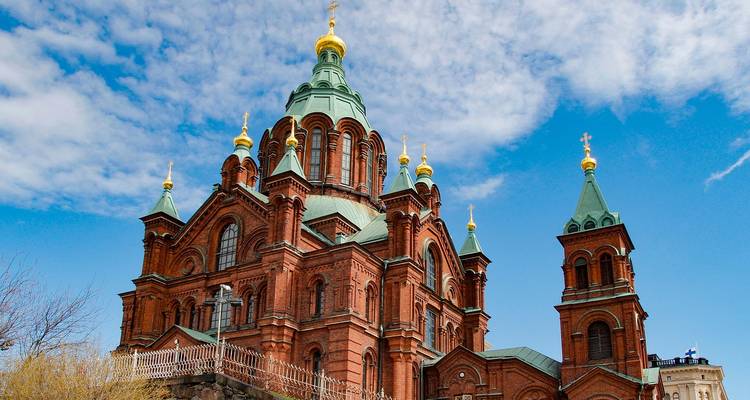 Église ornée en brique avec dôme en cuivre sous un ciel dégagé.