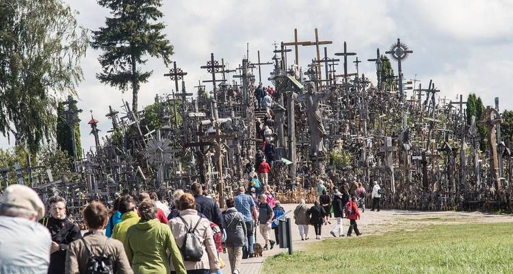 Colline couverte de nombreuses croix, visitée par des gens.