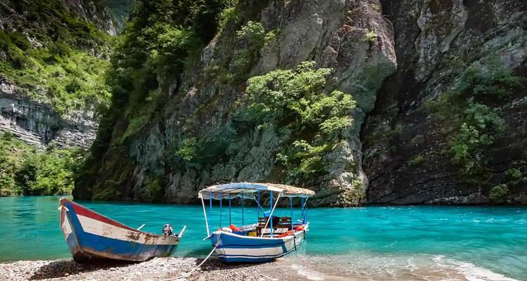 Barcos atracados cerca de acantilados rocosos.