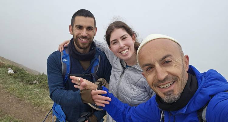 Tres excursionistas tomándose una selfie con un fondo brumoso.