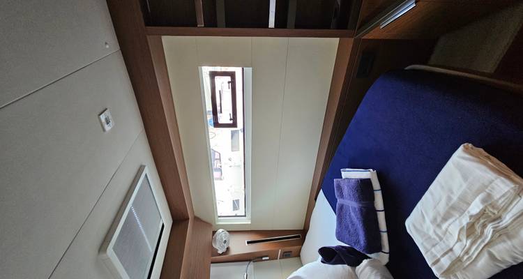 Yacht cabin with bed and window.