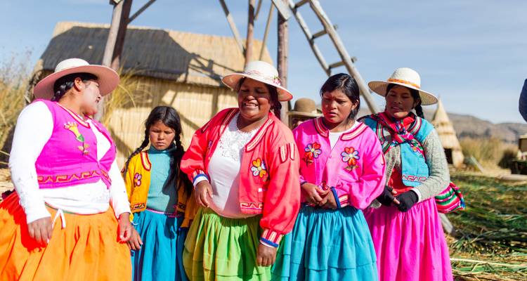 Group of people in traditional attire on reed islands.