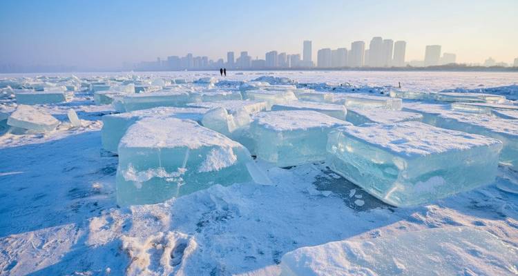 De gros blocs de glace avec l'horizon de la ville en arrière-plan.