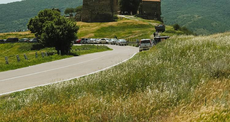 Route menant à un bâtiment historique sur une colline.