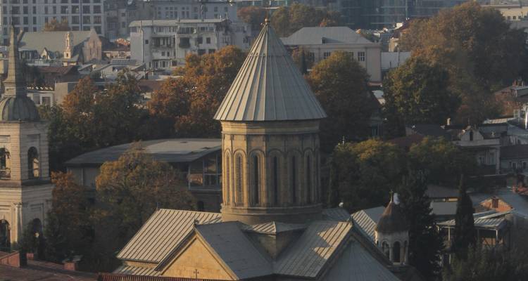 Église traditionnelle en pierre dans un environnement urbain.