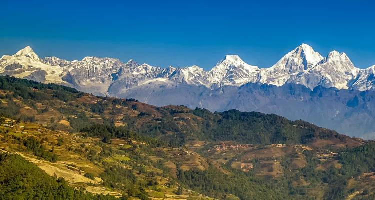 Vue panoramique de montagnes enneigées sous un ciel dégagé.