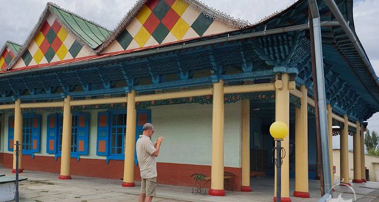 Homme prenant une photo d'un bâtiment traditionnel aux motifs colorés.