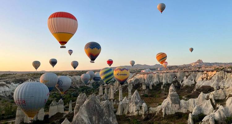 Des montgolfières planant au-dessus des formations rocheuses uniques de la Cappadoce.