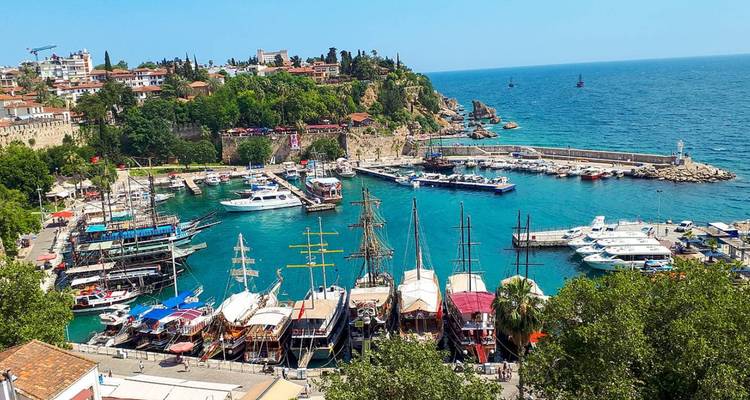 Port avec bateaux amarrés et ville côtière environnante.