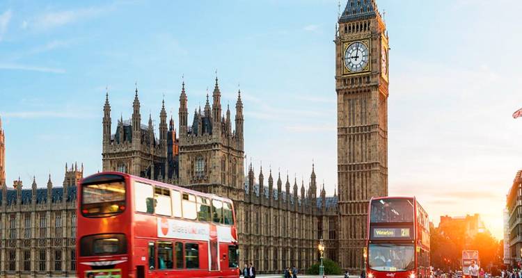 De Big Ben en omliggende architectuur met dubbeldekker bussen.