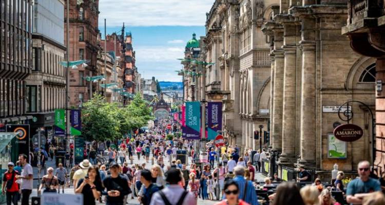 Een drukke straat vol met mensen en historische architectuur.