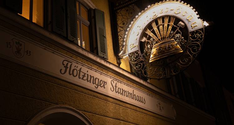 Nachtaufnahme eines beleuchteten Schildes an einem Gebäude in Deutschland.