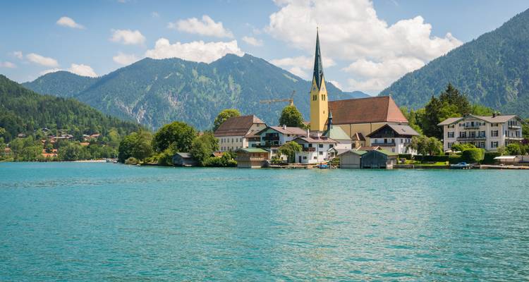 Malerische Seestadt mit Kirche und Bergen.