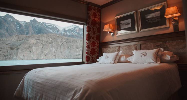 Une chambre d'hôtel confortable avec une fenêtre donnant sur un paysage rocheux.