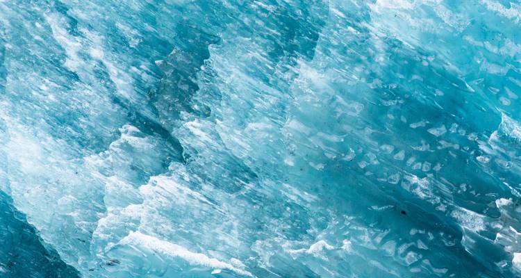 Gros plan sur des formations de glace aux textures et motifs complexes.