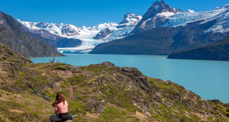 Personne profitant d'une vue panoramique sur les montagnes et un lac glaciaire.