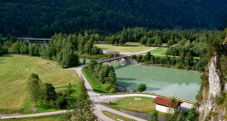 Pont traversant une rivière dans une vallée verdoyante et luxuriante.